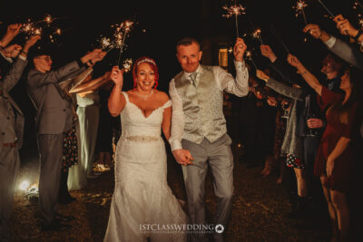 Bride and groom with sparklers at night wedding celebration