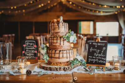 Rustic wedding cake with flowers and signage