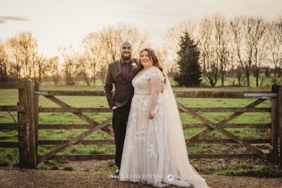 Wedding couple posing at sunset in countryside setting.