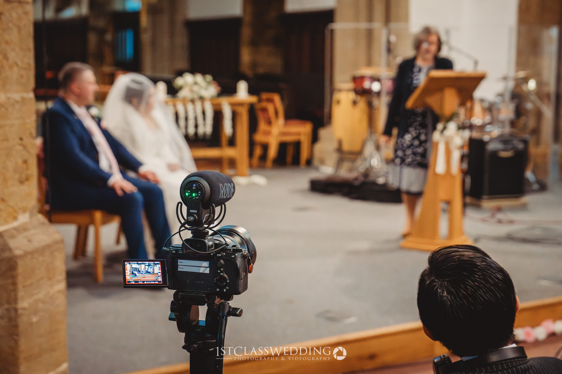 Wedding ceremony filming in progress inside church.