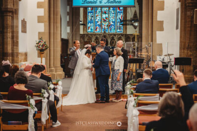 Couple at altar during wedding ceremony in church.