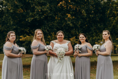 Bride and bridesmaids with bouquets outdoors.
