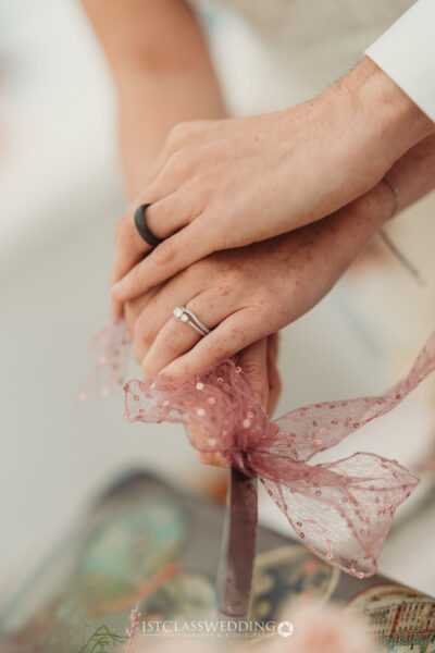Close-up of couple's hands with wedding rings
