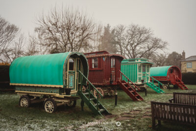 Traditional Romani caravans in misty British countryside.