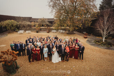 Wedding guests gathered outdoors at autumn venue.