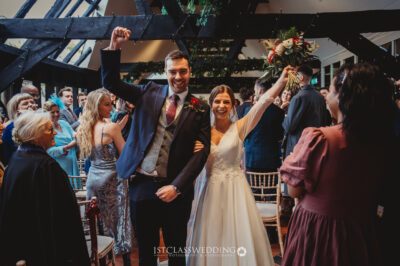 Joyful newlyweds celebrating with guests at wedding.