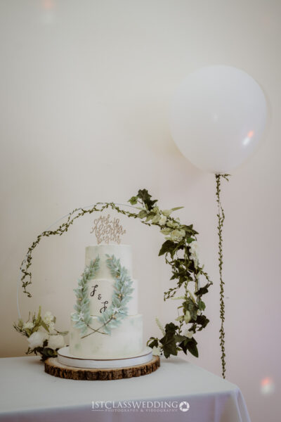 Elegant wedding cake with floral decoration and balloon.
