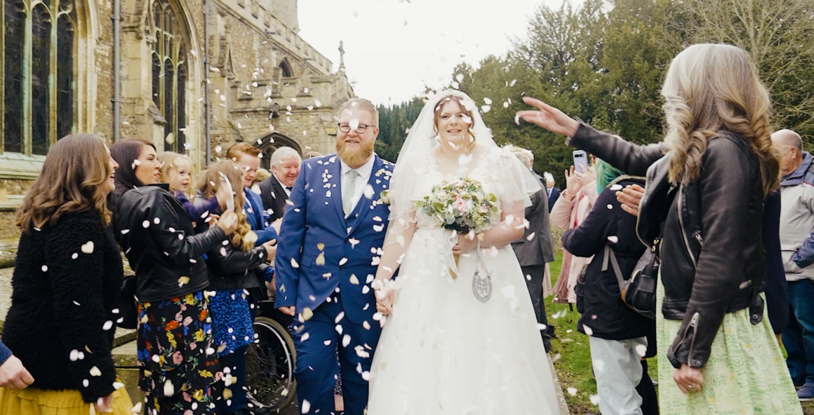 Bride and groom with confetti exit church wedding.
