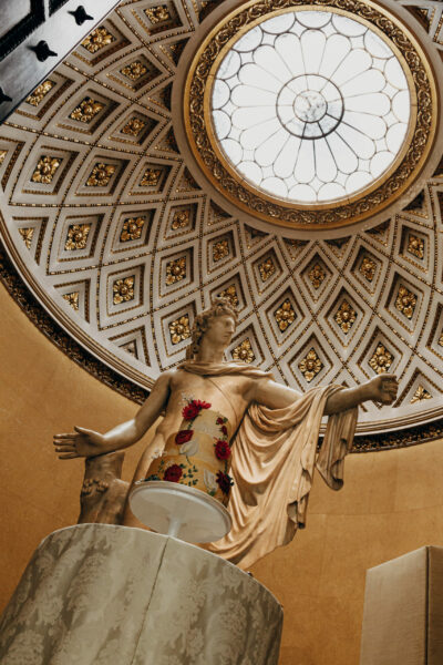 Statue under ornate dome with skylight.