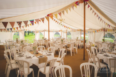 Decorated wedding marquee with tables and bunting.