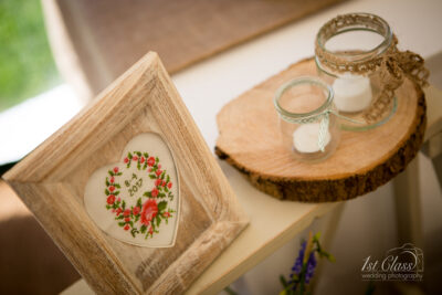 Rustic wedding decor with embroidered frame and candles.