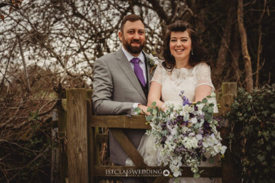 Happy couple with wedding bouquet outdoors