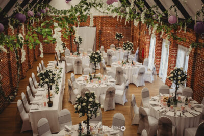Elegant barn wedding reception decor with floral arrangements.