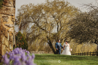 Couple walking under tree at countryside wedding at Crockwell Farm.