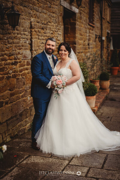 Couple posing in wedding attire with bouquet at Crockwell Farm