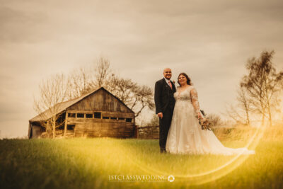 Couple posing in sunset wedding photography by barn at Donnigton Park Farmhouse