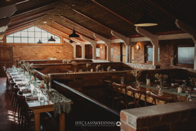 Rustic brick wedding venue interior with set tables at Donnigton Park Farmhouse.