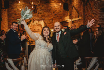 Joyful newlyweds celebrating with guests at wedding at Donnigton Park Farmhouse.