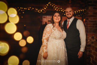 Couple at wedding with fairy lights backdrop.