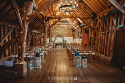 Rustic barn wedding venue with fairy lights and wooden beams.