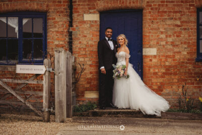 Bride and groom posing at Bassmead Manor entrance.