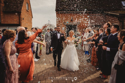 Couple showered with confetti, wedding celebration.