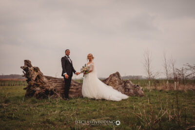Bride and groom outdoor wedding photo with log