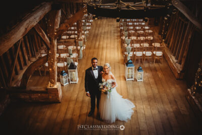 Bride and groom standing in rustic wedding venue.