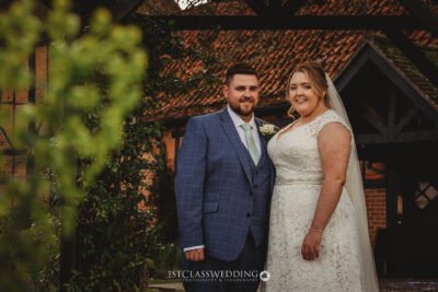 Bride and groom smiling at rustic wedding venue at Kingfisher Tithe Barn Wedding Venue Bedford..