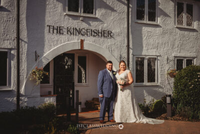 Bride and groom smiling outside The Kingfisher venue.