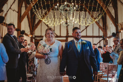 Bride and groom walking down the aisle after ceremony at Kingfisher Tithe Barn Bedford.