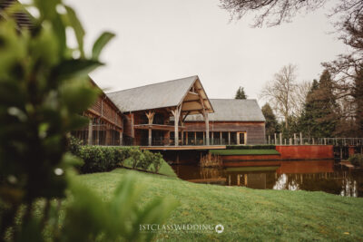Rustic wedding venue beside tranquil pond with greenery.