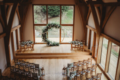 Rustic wedding venue interior with floral arch.
