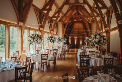 Elegant barn wedding venue setup with floral decorations.