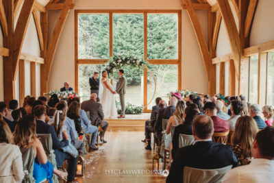 Wedding ceremony in rustic hall with guests.
