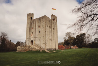 Medieval castle with flag on cloudy day in England.