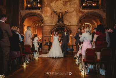Bride and groom smiling at wedding ceremony at Hedingham Castle.