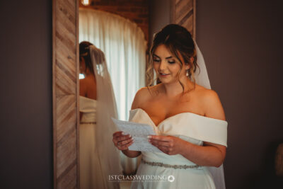 Bride reading letter on wedding day.