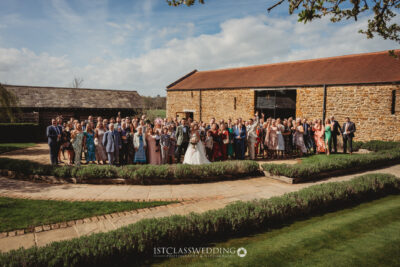 Wedding guests posing with bride and groom outdoors at Dodfrod Manor