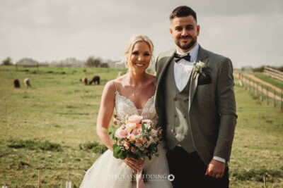 Bride and groom smiling in countryside wedding.
