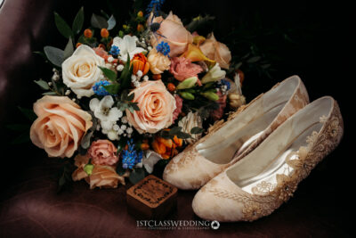 Elegant bridal shoes with vibrant wedding bouquet.