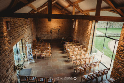 Rustic barn wedding venue interior with arranged chairs.