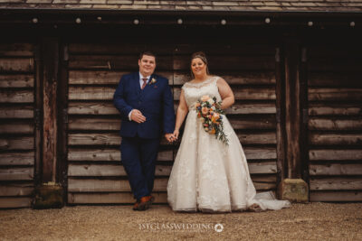 Bride and groom posing at rustic wedding venue.