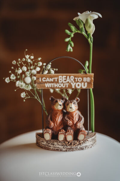Bear figurines with romantic sign on wedding cake topper.