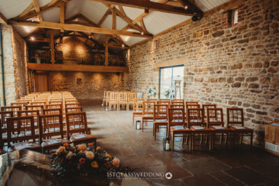 Rustic wedding venue interior with stone walls and wooden beams.